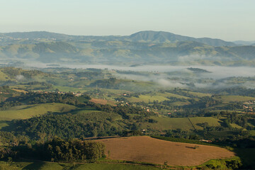 Obraz premium Serras cobertas com névoa, vegetação e céu azul. 