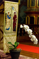 Bandeira de tema religioso com flor orquídea de cor branca.  