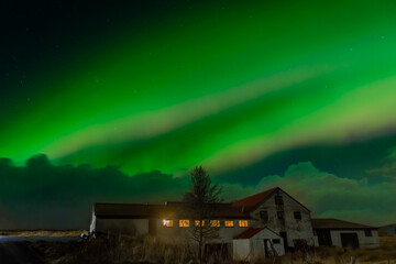 Northern Light,  spectacular Aurora borealis over a farm in Iceland