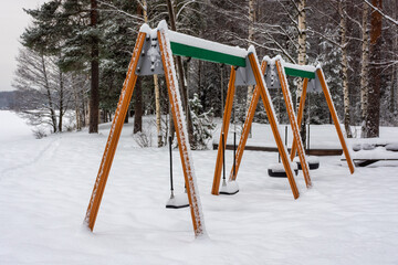Snowy swings on the shore of a frozen  lake in Finland