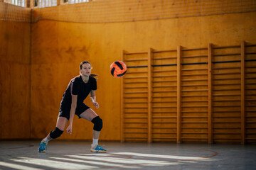 A sportswoman in action playing volleyball on training.