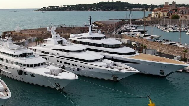 Super Mega Yachts in the French Riviera in the port of Antibes - Aerial sunrise flyover