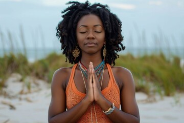 African American woman practicing yoga and meditation on beach Blissful girl focusing on spiritual fitness for mindfulness health and relaxation in