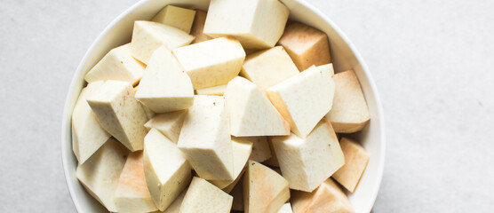 Overhead view of Nigerian white yam cubes in a white ceramic bowl, African yam cut into large cubes for cooking