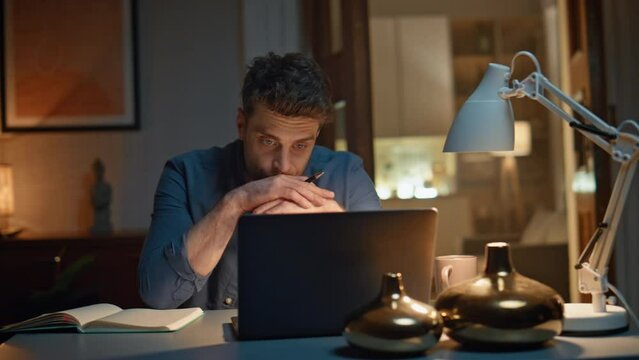 Guy speaking online meeting computer at night home closeup. Man video calling