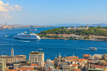 Naklejka na ściany i meble Galata Tower aerial view on Istanbul skyline featuring the bosphorus strait and a cruise ship on a clear sunny day in Turkey.