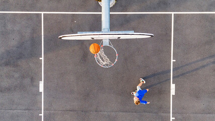 Street basketball. A bird's-eye view of a boy playing basketball on an playground with a basketball...