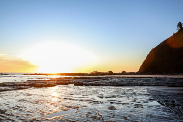 Sunset above rocks and tide pools on the Oregon Coast in Lincoln City at Roads End.   Glistening...