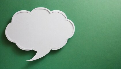 White paper cut out speech bubble shape set on green paper background