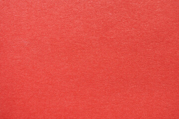 Fototapeta premium Close-up view of bright red textured paper, perfect for backgrounds or graphic design projects.