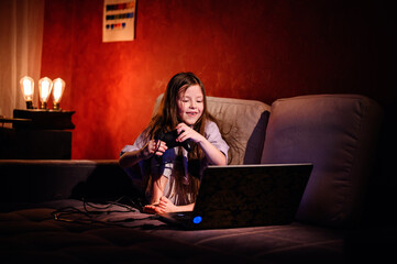 Intense focus is etched on a young girl's face as she maneuvers a game controller, deeply immersed...
