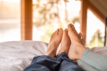 Obraz na płótnie Canvas Closeup Couple's Feet Relaxing Resting In Bed at Home bedroom Enjoying Peaceful Quiet Weekend Day Off .Love and Happy relationships concept 