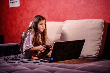 A young girl is deeply focused while playing a video game, her expression a blend of concentration...