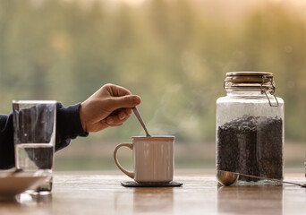 Person Making Enjoying Sterring a Hot Cup of Coffee 