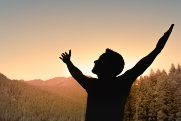 Life if Beautiful! Young Man Facing Mountain Sunset Rejoices, smiles looking up to the sky, enjoys life and summer, nature, adventure and feelings of freedom, hope, and happiness