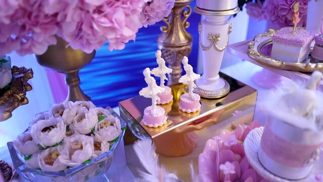 sweets table with pink swan and decorative ballerina at birthday party
