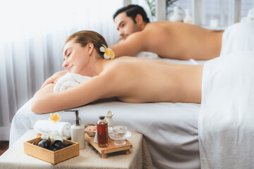 Obraz na płótnie Canvas Caucasian couple customer enjoying relaxing anti-stress spa massage and pampering with beauty skin recreation leisure in day light ambient salon spa at luxury resort or hotel. Quiescent