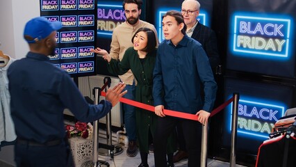 Crazy clients pushing man on floor during black friday sales, crowd of obsessed mad customers...