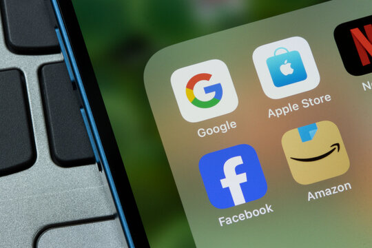 Portland, OR, USA - Feb 14, 2024: App icons representing the Big Four tech companies, including Google, Apple, Meta, and Amazon, are seen on the screen of an iPhone. Big tech competition concept.
