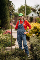 A young woman pulls weeds in her huge garden in the spring, clearing the garden after winter