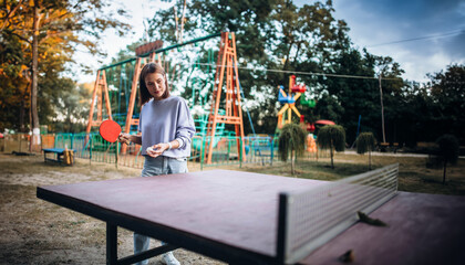 young woman playing ping pong in an amusement park
