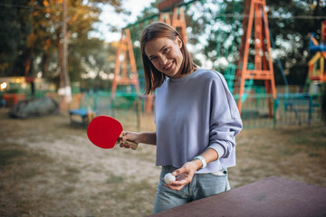 young woman playing ping pong in an amusement park