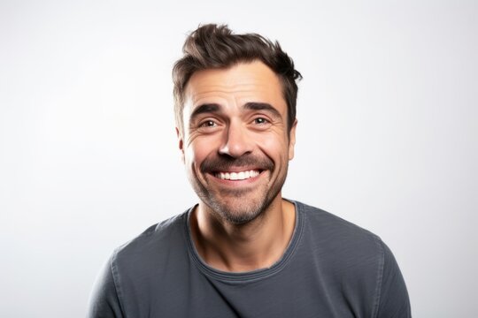 Portrait of a handsome smiling man on grey background. Looking at camera.