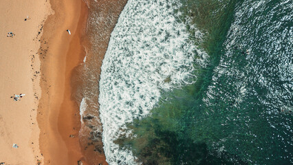 Stunning ocean view of the waves and beach in the Northern Beaches of NSW, Sydney, Australia. The view was captured from above using a drone.