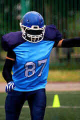 American football player in blue uniform with nomber 87 before kicking the ball	
