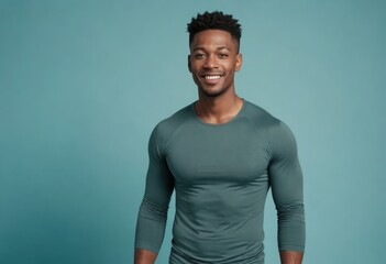 Obraz premium Muscular man in a fitted green tee, his broad smile and athletic build indicating a healthy, active lifestyle.