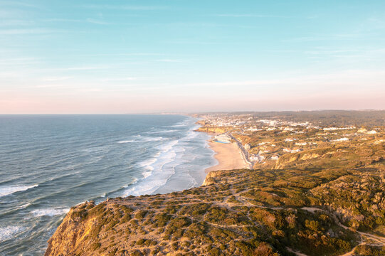 Sunset on the beach Praia Grande, Portugal. Beautiful sunset on the Portuguese beach Praia Grande, in Portugal. Beach of Praia Grande. View of Atlantic beach and big waves. Colares, Sintra, Portugal.