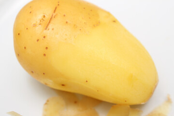potato with skin and without skin. half peeled potato. potato details.