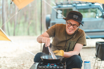 キャンプ場で調理を楽しむ男性キャンパー（ソロキャンプ）
