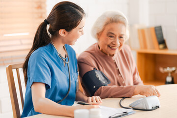 Medical health insurance service, Asian caregiver doctor examine older patient use blood pressure gauge. Young woman therapist nurse nursing home taking care to senior elderly woman