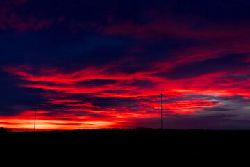 Obraz premium Dramatic red sunrise and the calm highway in prairies in winter.