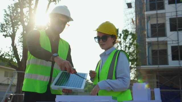 Team young engineer or architect meeting and planning installation solar panel at construction site, engineer talking and discussing with partner for installation solar cell, industry concept.