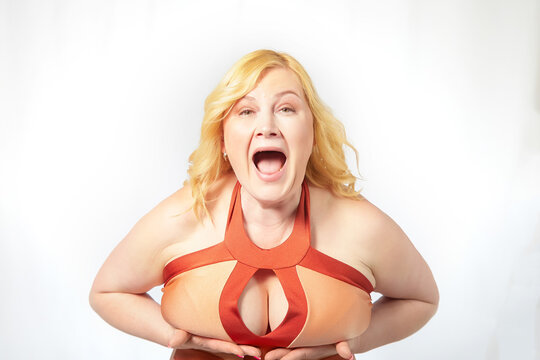 A fat middle-aged woman with a size five breast is showing it off. Health difficulties with large breasts. Plastic surgery