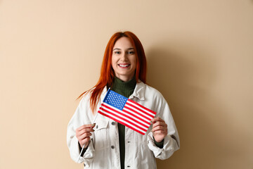 Fototapeta premium Young woman with USA flag on beige background