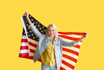 Mature woman with USA flag on yellow background