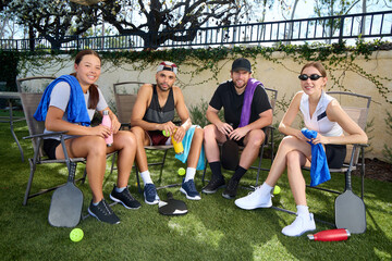 A group of friends take a break from a pickleball game