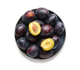 Plate with ripe plums on white background