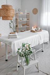 Interior of spa salon with couch and burning candles