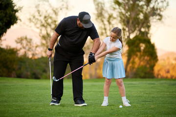 A father and Daughter play golf on a golf course