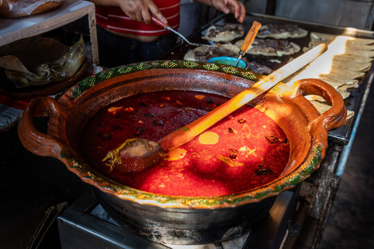 Mujer en mercado de Tepoztlan, preparando comida t&iacute;pica mexicana como quesadillas, con una olla de menudo a lado. 