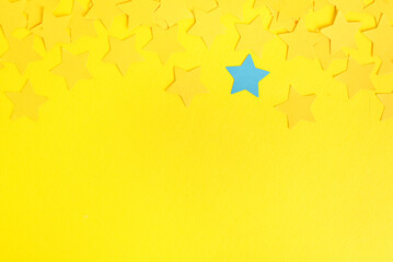 One blue star among yellow ones on color background. Concept of uniqueness