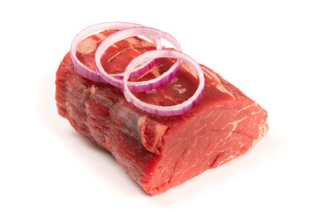 A piece of beef tenderloin roast garnished with red onion slices isolated on white
