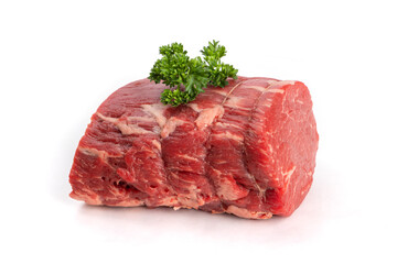 A piece of beef tenderloin roast with parsley garnish isolated on white