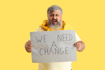 Protesting mature man holding placard with text WE NEED A CHANGE on yellow background. Impeachment...