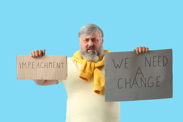 Protesting mature man holding placards on blue background. Impeachment concept