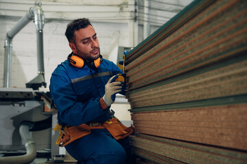 Contemporary Carpenter Working in factory, operating modern machines. Portrait of modern carpenter...